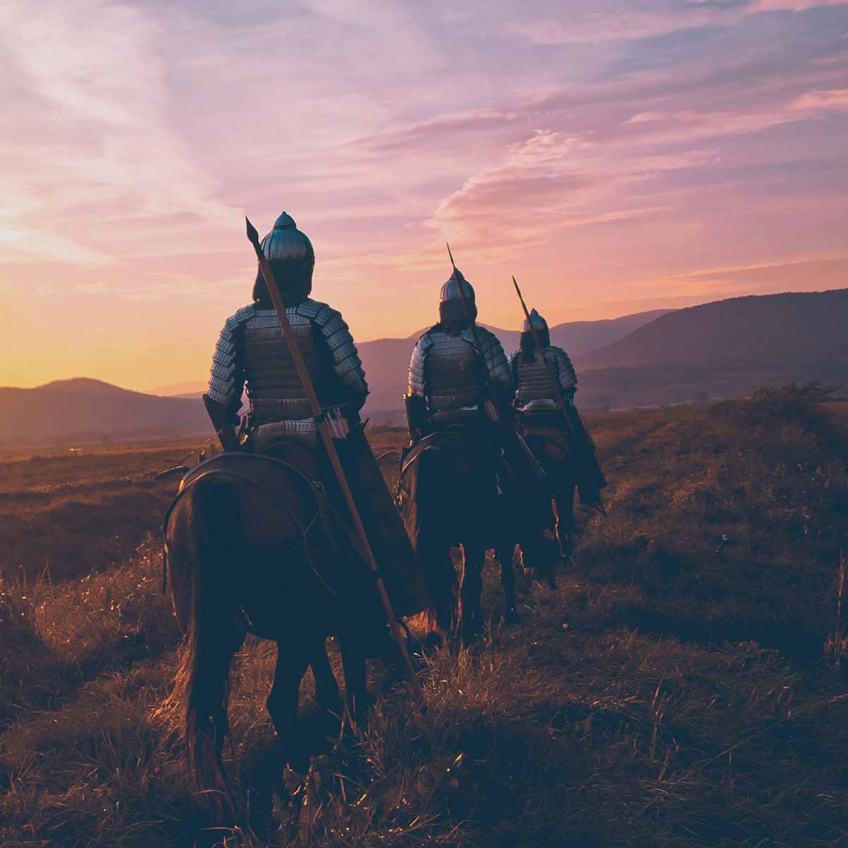 Three armed warriors on horses in a field